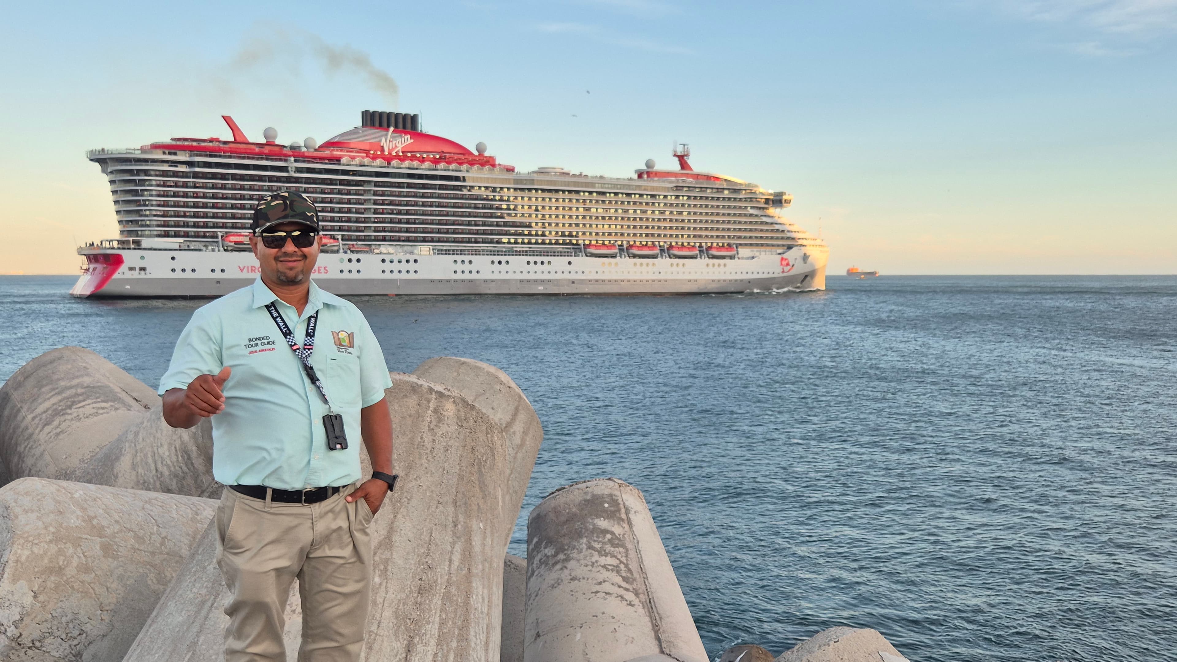 Guía de turistas certificado SECTUR frente a un crucero en el puerto de Mazatlán